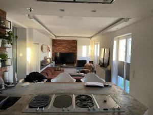 a living room with a kitchen and a living room with a couch at Private Loft with Rooftop & Jacuzzi in City Center in Düsseldorf