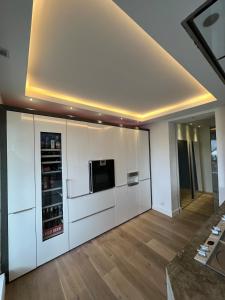 a large kitchen with white cabinets and a microwave at Private Loft with Rooftop & Jacuzzi in City Center in Düsseldorf +7 photos
