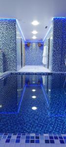 a blue bathroom with a tub with blue tiles at Olimpia Hotel&Spa in Odesa