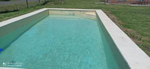 a swimming pool with blue water in a yard at El buho in Roldán
