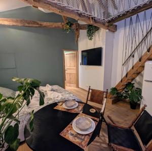 a dining room with a table and chairs and a tv at Bordeaux Autrement - Une escapade dans la Canopée in Cenon