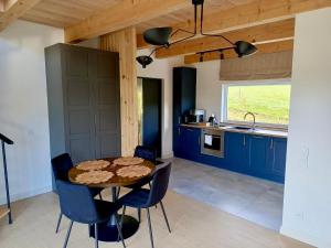 a kitchen with blue cabinets and a table and chairs at Słoneczny Stok in Małastów
