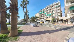 une rue avec un palmier et un bâtiment dans l'établissement Apartamento 60, à Almuñécar