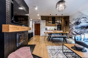a living room with a fireplace and a dining room at APART Rogatek Szlachetny Pod Giewontem in Kościelisko
