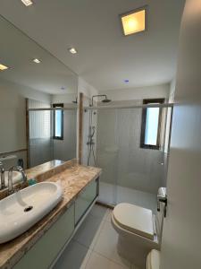 a bathroom with a sink and a toilet and a shower at Apartamento Iberostate Praia do Forte, 2 quartos in Mata de Sao Joao