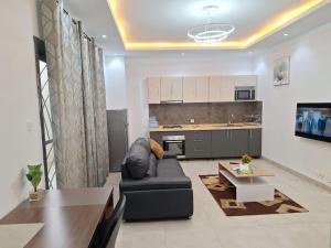 ein Wohnzimmer mit Sofa und Tisch in der Unterkunft Chez TIM POINT-E in Dakar