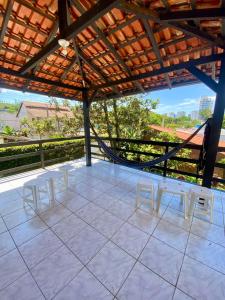 a patio with white tables and chairs on a roof at Casa Ampla na Brava in Itajaí