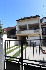 ein weißes Haus mit einem schwarzen Zaun davor in der Unterkunft Family home between Paris and Disneyland in Noisy-le-Grand
