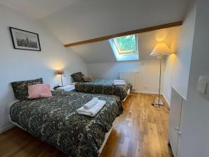 ein kleines Zimmer mit 2 Betten und einer Lampe in der Unterkunft Family home between Paris and Disneyland in Noisy-le-Grand