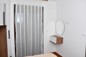 a white room with a mirror and a dresser at Apartman Kragujevac in Kragujevac