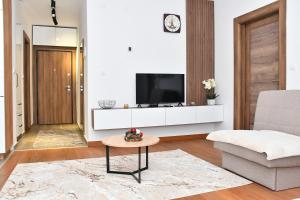 a living room with a tv on a white wall at Apartman Kragujevac in Kragujevac