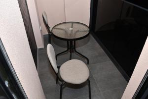 a small table and a chair in a room at Apartman Kragujevac in Kragujevac +2 photos