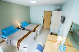 ハジャイにあるSritrang Placeのベッド2台とソファが備わる小さな客室です。