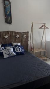 une chambre avec un lit avec des draps et des oreillers bleus dans l'établissement Kitnet Boraceia mar e sol, à Bertioga