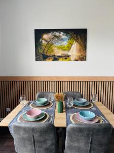 a table with chairs and plates and wine glasses at Charmante Auszeit im Harz in Blankenburg
