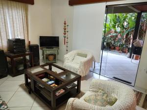 Una sala de estar con dos sillas y una mesa de café. en Solar Grace casa 02, en Bombinhas