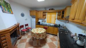 a kitchen with wooden cabinets and a table and chairs at Cueva Rincón Bustamante in Gorafe