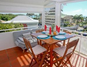 d'une table et de chaises sur un balcon avec vue. dans l'établissement Studio Mojito vue mer,piscine avec cuve eau et accès plage et piscine ANSE DES ROCHERS, à Saint-François