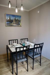 a dining room table with chairs and a painting on the wall at Faria's House 2 in Feiteiras