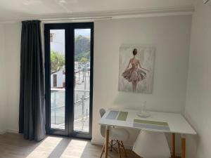 a room with a table and a picture of a woman at CGD São Vicente Apartments in São Vicente