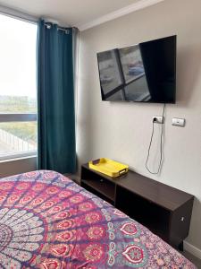 a bedroom with a bed and a mirror and a window at la serena 1 dormitorio in La Serena