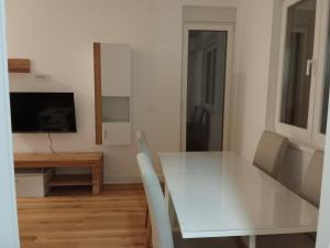 a dining room with a white table and chairs at Vida in Sremska Mitrovica