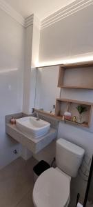 ein Badezimmer mit einer weißen Toilette und einem Waschbecken in der Unterkunft Jk LOFT à beira-mar de CAPÃO DA CANOA, com ar condicionado split in Capão da Canoa
