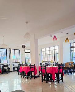 a dining room with tables and chairs with red table cloth at Hostal COSTA AZZURRA in Cerro Azul +31 photos