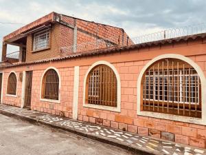 a pink brick building with three arched windows at Leño Verde in Espinal