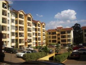 a large apartment complex with cars parked in a parking lot at Sunninghills in Nairobi