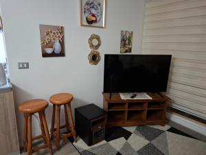 Ein Zimmer mit zwei Hockern und einem Computermonitor auf einem Tisch in der Unterkunft GiGIi in La Serena