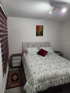 een slaapkamer met een bed en een schilderij aan de muur bij GiGIi in La Serena
