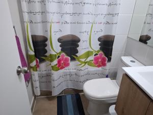 een badkamer met een toilet en een douchegordijn met bloemen bij GiGIi in La Serena +4 foto's