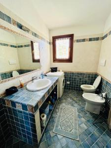 Un baño con lavabo, inodoro y espejo. en Appartamento Costa Smeralda, en Cannigione