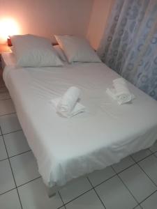a large white bed with two pillows on it at Lagoon Studio Plage in Schœlcher