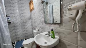 a white bathroom with a sink and a toilet at Appartement B à 7min de l’aéroport de Marrakech in Marrakech +20 photos