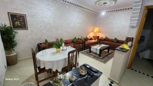 a living room with a table and a couch at Appartement B à 7min de l’aéroport de Marrakech in Marrakech