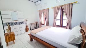 a bedroom with a bed and a window at Casa de Lami in Dalung