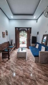 a living room with a blue couch and a table at Casa de Lami in Dalung