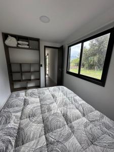 Un dormitorio con una cama grande y una ventana en Nina apart Meliquina, en San Martín de los Andes