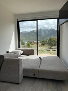 Un dormitorio con dos camas y una gran ventana. en Nina apart Meliquina, en San Martín de los Andes