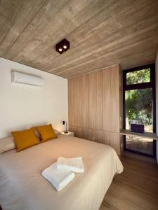 ein Schlafzimmer mit einem großen weißen Bett mit einem Fenster in der Unterkunft Terrazas del Bosque in La Pedrera + 26 Fotos