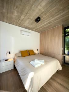 ein Schlafzimmer mit einem großen Bett und einer Holzdecke in der Unterkunft Terrazas del Bosque in La Pedrera