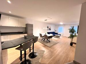a kitchen and living room with a table and chairs at Designer Apartment in Sinsheim Erstbezug 75 TV mit Netflix und offene Küche WeHome Premium in Sinsheim