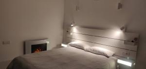 a bedroom with a bed and a fireplace at Apartamento con vistas al mar in Viladecáns