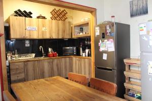 a kitchen with a table and a refrigerator at Hostal Mirenart in Valparaíso