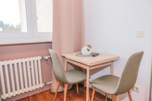 a small table and chairs in a room with a window at GMA Apartment B12 in Lahr