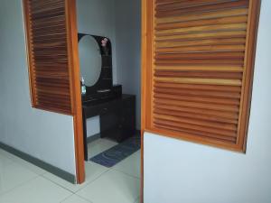 une salle de bain avec une porte en bois et un miroir dans l'établissement KKs room 1, à Nadi
