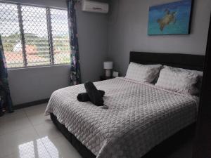 un animal farci assis sur un lit dans une chambre dans l'établissement KKs room 1, à Nadi