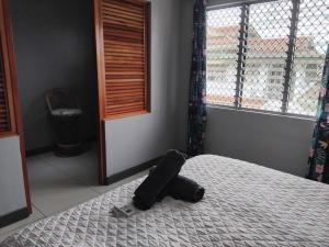 un objet noir posé sur un lit dans une chambre dans l'établissement KKs room 1, à Nadi